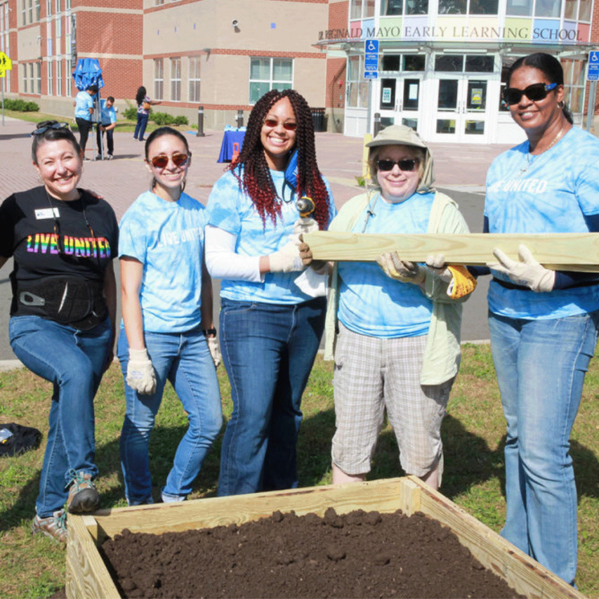Women United members build an outdoor garden for students